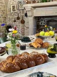 uma mesa com pães e outros doces em Les Chambres du parc 