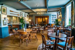 um restaurante com mesas e cadeiras num quarto em Mytton and Mermaid - Brunning and Price em Shrewsbury