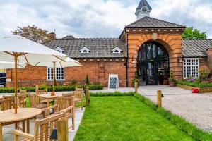 un patio esterno con tavoli e ombrelloni di fronte a un edificio di Mytton and Mermaid - Brunning and Price a Shrewsbury