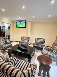 a living room with couches and a flat screen tv at Limpopo Guest Manor in Polokwane