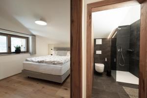 een slaapkamer met een bed en een badkamer met een douche bij Alpine Lofts M26 in Grossarl