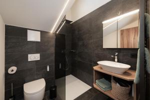 a bathroom with a white toilet and a sink at Alpine Lofts M26 in Grossarl