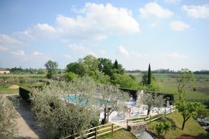 uitzicht op een zwembad met een hek en bomen bij Cà Donzella in Lazise