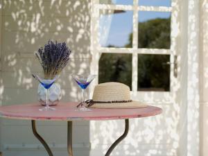 Una mesa rosa con sombrero y gafas. en Demeure de charme, piscine, centre St Rémy à pied en Saint-Rémy-de-Provence