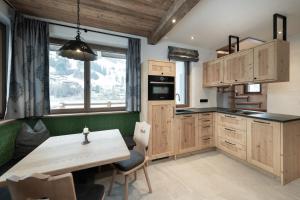 a kitchen with wooden cabinets and a wooden table at Alpine Lofts M26 in Grossarl
