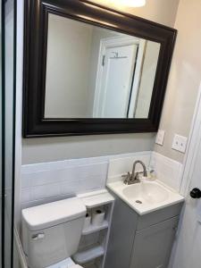 uma casa de banho com um WC, um lavatório e um espelho. em Downtown Hidden Gem em Columbia