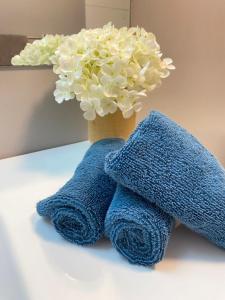 two towels sitting next to a vase with flowers at lovely home in Calgary