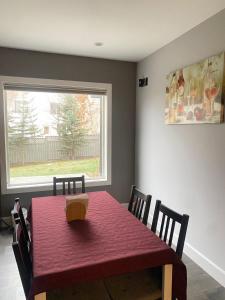 uma sala de jantar com uma mesa vermelha e uma janela em lovely home em Calgary