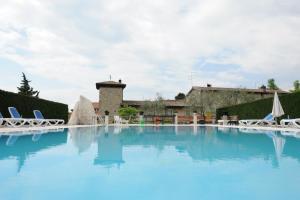 a large pool with blue water in front of a building at Cà Donzella in Lazise
