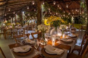 a dining room with tables and chairs with flowers at Resort Fazenda 3 Pinheiros in Engenheiro Passos +37 photos