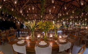 a dining room with a table with candles and flowers at Resort Fazenda 3 Pinheiros in Engenheiro Passos