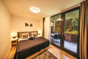 a bedroom with a bed and a large window at Apartmán Mlýn Herlíkovice 205 in Vrchlabí