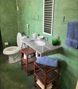 uma casa de banho com um lavatório, um WC e um espelho. em Pousada da Chris em Maxaranguape