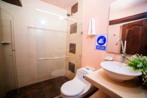 a bathroom with a toilet and a sink and a shower at Hotel La Casona Mompox in Mompós