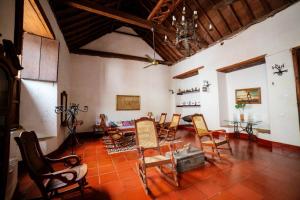 a living room with a bunch of chairs and a table at Hotel La Casona Mompox in Mompós