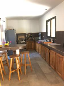 a kitchen with wooden cabinets and wooden stools at Villa L'Aldiana 