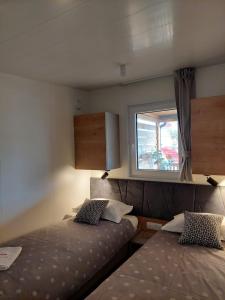 a small bedroom with two beds and a window at Julija Mobile Lux in Vodice