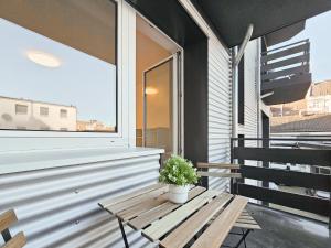 un banco de madera en un balcón con una maceta en RAJ Living - 2 or 3 Room Apartments - 15 Min zur Messe DUS & 10 Min Old Town DUS, en Düsseldorf