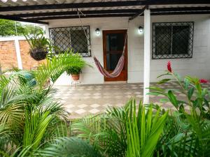 a front porch of a house with a hammock on it at Las villas de Yoly in Playas