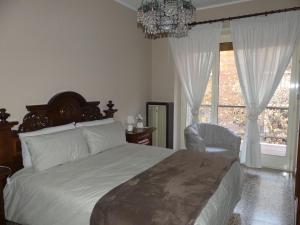 1 dormitorio con 1 cama, 1 silla y 1 lámpara de araña en SERVETTOHOME en Turín