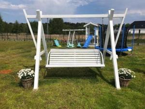 a white bench in a yard with a playground at New holiday homes near the sea in Niechorze in Niechorze