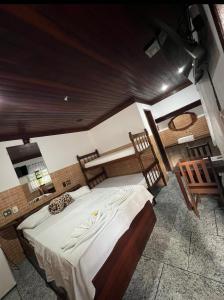 a bedroom with a large bed and a wooden ceiling at Pesque pague pousada do Carlinho in Pinheiral +37 photos
