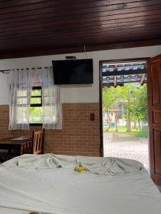 a bedroom with a bed and a television on the wall at Pesque pague pousada do Carlinho in Pinheiral