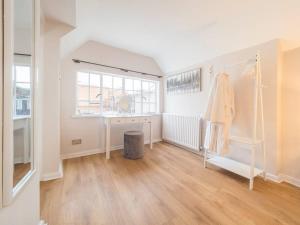 a white room with a window and a wooden floor at Hamlet's Nest in Stratford-upon-Avon