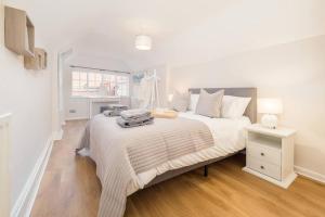 a white bedroom with a large bed and a table at Hamlet's Nest in Stratford-upon-Avon