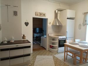 a kitchen with white cabinets and a table and a dining room at Kosken Helmi in Kaustinen