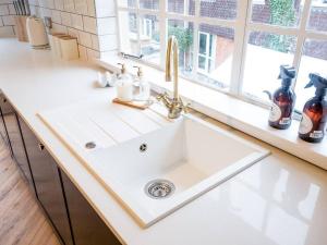 a white sink in a kitchen with a window at Hamlet's Nest in Stratford-upon-Avon +1 photo