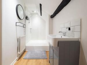 a white bathroom with a sink and a mirror at Hamlet's Nest in Stratford-upon-Avon