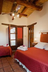 a bedroom with two beds and a ceiling at El Hospedaje in Cafayate