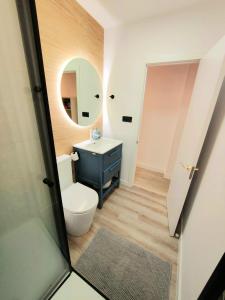 a bathroom with a toilet and a sink and a mirror at ALMERIA SOL Y SUR APARTMENTO - Netflix y Parking GRATUITO in Almería