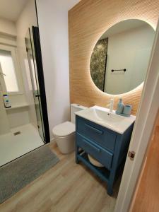 a bathroom with a blue sink and a mirror at ALMERIA SOL Y SUR APARTMENTO - Netflix y Parking GRATUITO in Almería