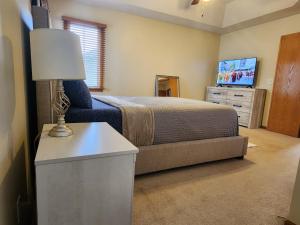 ein Schlafzimmer mit einem Bett und einem Tisch mit einer Lampe in der Unterkunft Pet friendly,3 Queen beds, One-Full bed with Fast free WIFI in Omaha