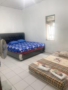 a bedroom with two beds in a room with a window at Wijaya homestay in Subang