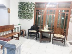 a room with benches and a table and chairs at Wijaya homestay in Subang