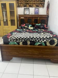 Bett in einem Zimmer mit Holzrahmen in der Unterkunft Wijaya homestay in Subang