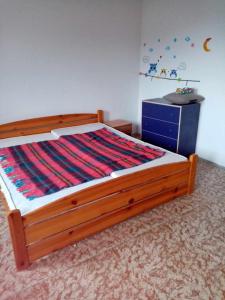 a bed with a wooden frame and a dresser in a bedroom at Pohodlná bytovka in Prešov +2 photos