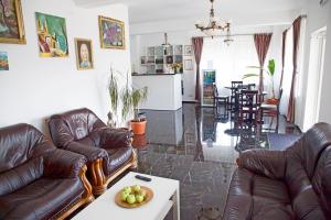a living room with couches and a table with a bowl of fruit at Hotel Nova Residence 2 in Popeşti-Leordeni