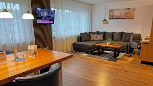 ein Wohnzimmer mit einem Sofa und einem Tisch in der Unterkunft HIL - Hotel im Lus Schopfheim in Schopfheim