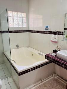 a white bathroom with a tub and a sink at Casa para Descanso in Campos do Jordão