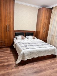 um quarto com uma cama grande e armários de madeira em Уютная квартира Курмангазы 5 em Atyrau