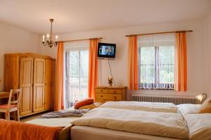 two beds in a bedroom with orange curtains at Scheibenhof in Bad Gastein