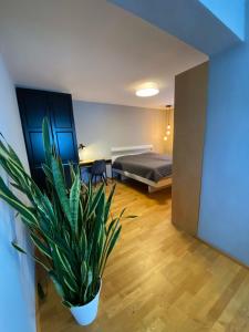 um quarto com uma cama e um vaso de plantas em Wohnung im Grünen am Stadtrand, 50 m2, eigener Garten mit Terrasse, eigener Eingang, kostenloses Parken em Salzburgo