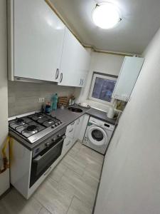 uma cozinha com um fogão e uma máquina de lavar roupa em Top House em Vaslui