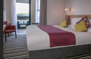 een hotelkamer met een groot bed en een stoel bij Best Western Lancaster Morecambe Lothersdale Hotel in Morecambe