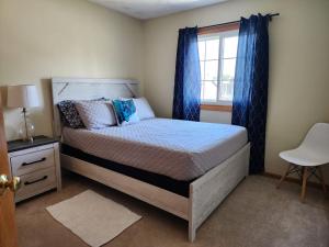 um quarto com uma cama com cortinas azuis e uma janela em Pet friendly,3 Queen beds, One-Full bed with Fast free WIFI em Omaha