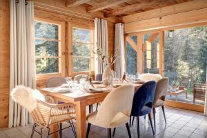 a dining room with a wooden table and chairs at Chalet Hollygotty - OVO Network in La Clusaz